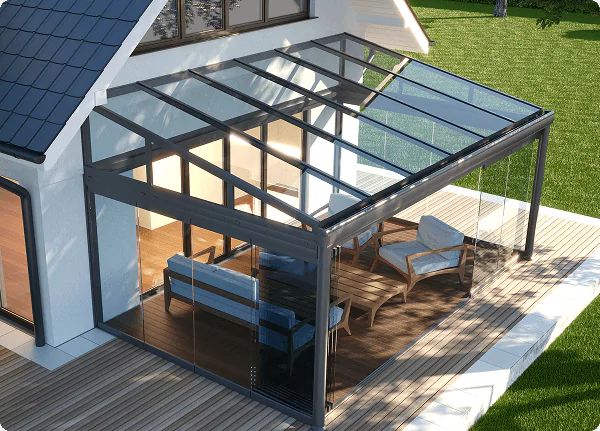 Glass-enclosed patio with modern furniture and slanted transparent roof attached to a house.