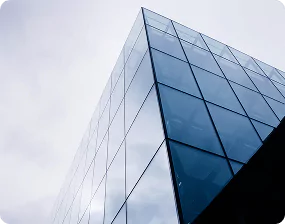 Modern glass building facade reflecting the sky, representing custom glass sizes for construction projects