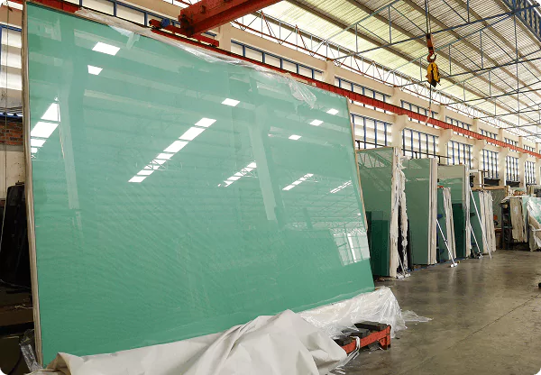 Large tempered glass panels stored in a warehouse, ready for delivery and installation