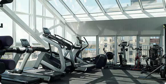 Upgrade Your Gym with Commercial‑Grade Glass & Mirrors beside a bright gym photo with treadmills.
